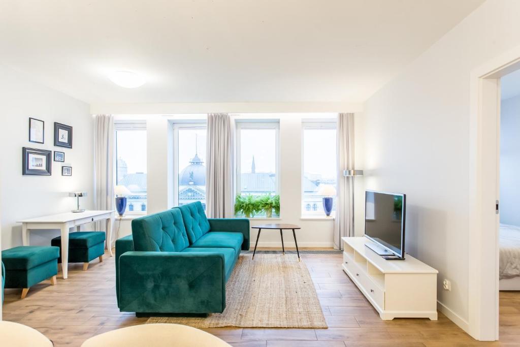 什切青Space Apartments Szczecin的客厅配有蓝色的沙发和电视