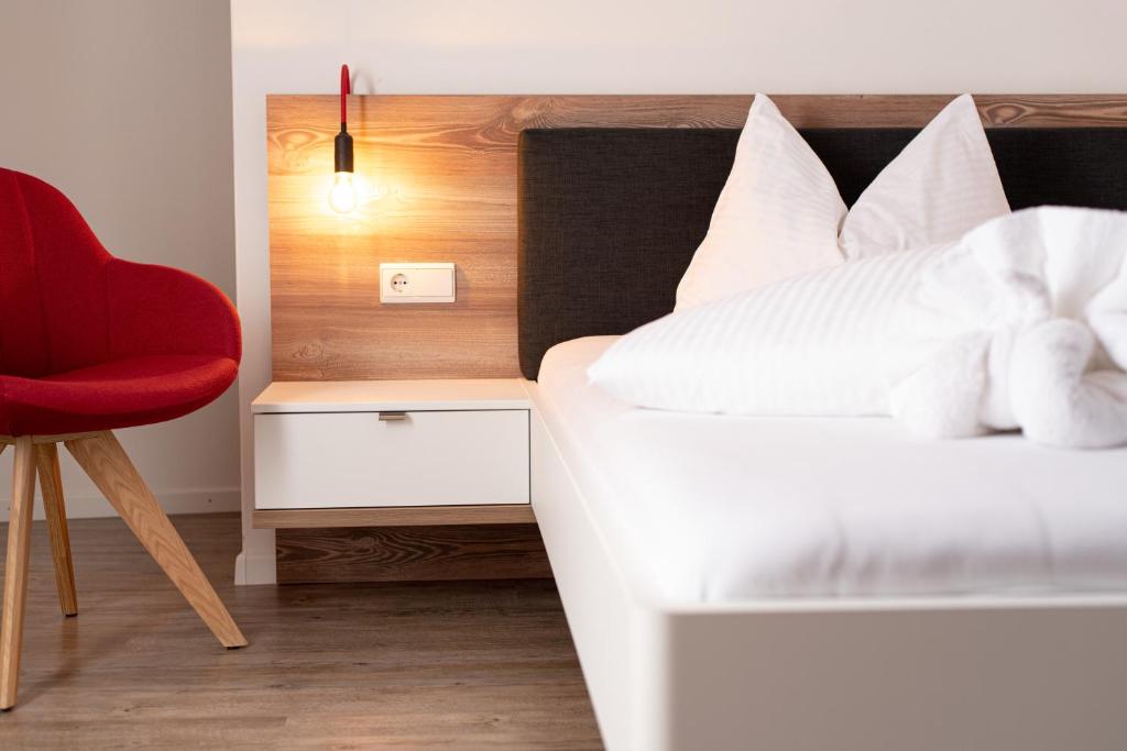西兰德罗Pension Pernthaler的一间卧室配有一张床和一张红色椅子