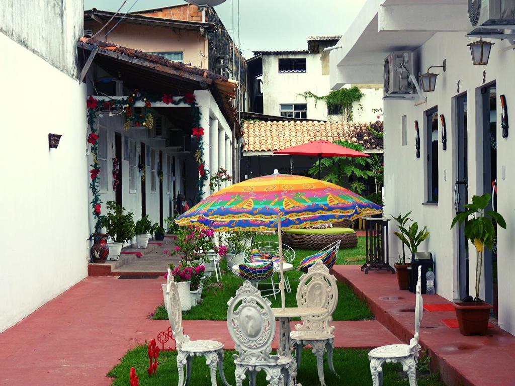 索雷Pousada Solar Encanto do Marajó的一个带桌椅和遮阳伞的庭院