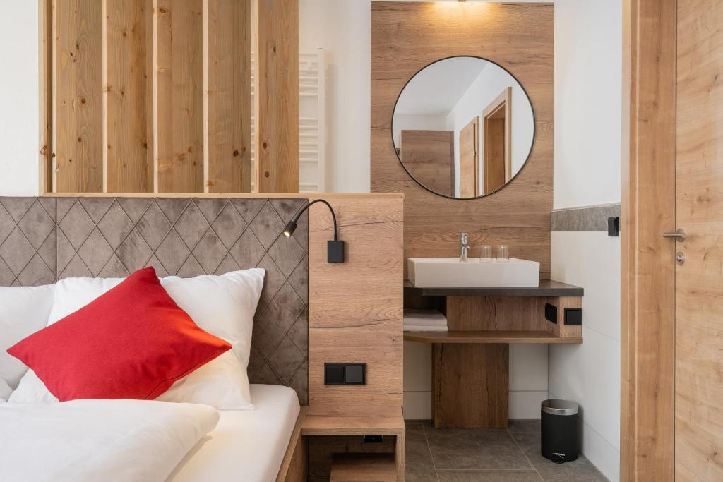 克雷纳尔Bergappartements Pröll的一间卧室配有一张带镜子和水槽的床