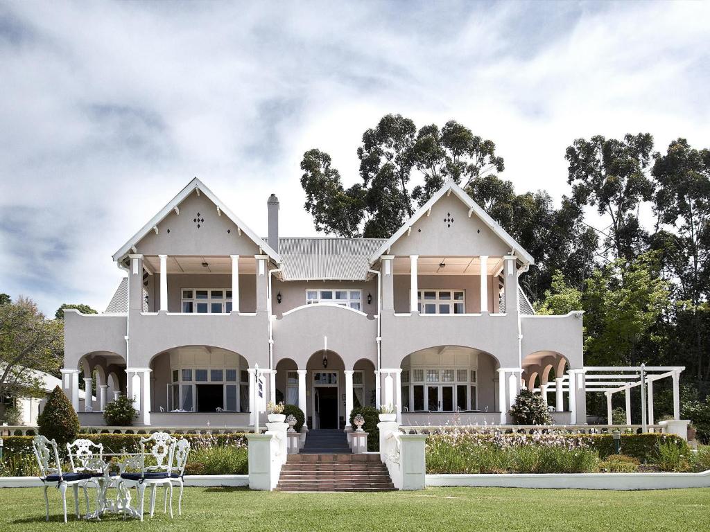 克尼斯纳帕克斯庄园酒店的草坪上带椅子的大型白色房屋