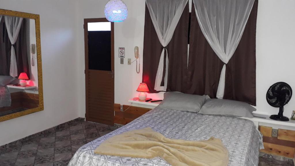 兰巴里Pousada São Pedro的一间卧室配有一张床和一面大镜子