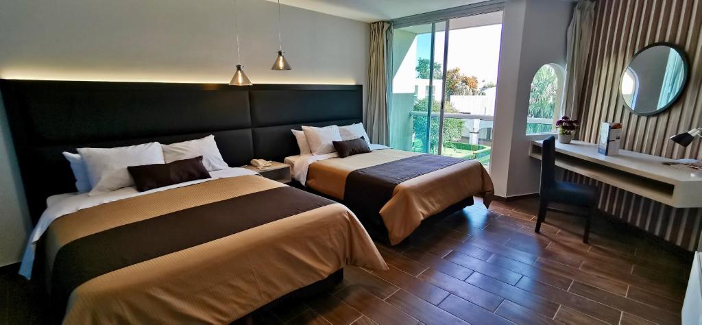 乔卢拉Hotel Posada Señorial的酒店客房配有两张床和一张书桌