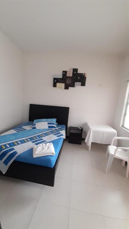 洛佩斯港Hotel Zenit de Colombia的卧室配有一张床,墙上有十字架