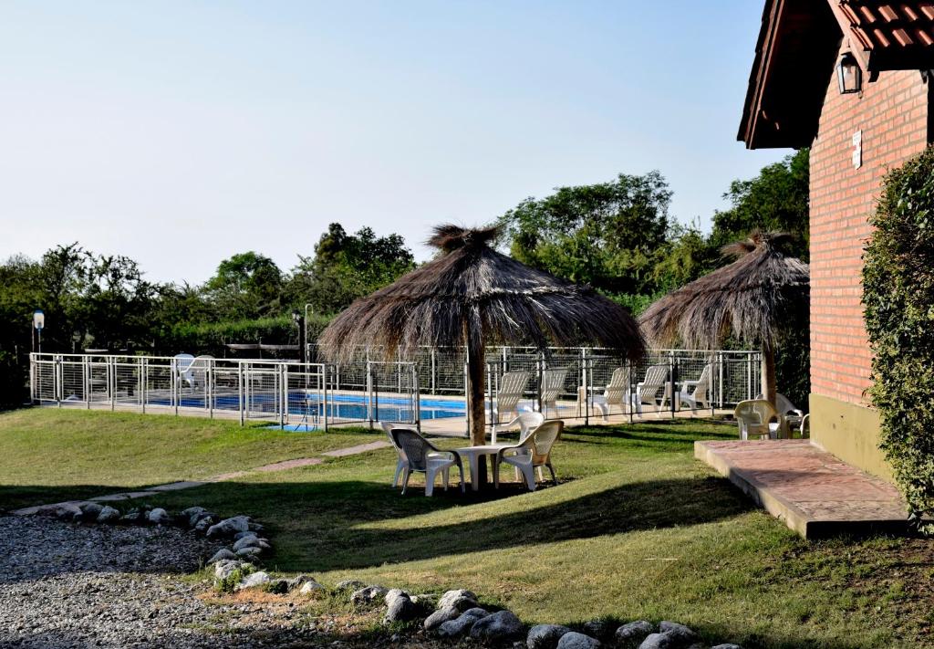 梅洛卡瓦尼亚斯巴宾库山林小屋的一个带桌椅和遮阳伞的游泳池