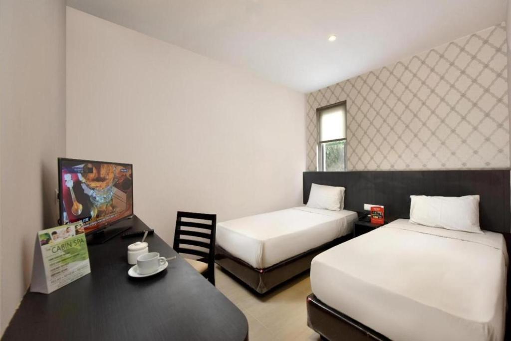 LubukpakamCREW EXPRESS Hotel的酒店客房设有两张床和一张桌子