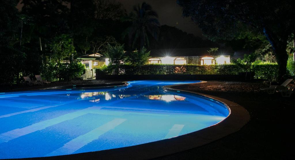 Aguas ClarasMalekus Mountain Lodge的夜间在院子里的大型蓝色游泳池