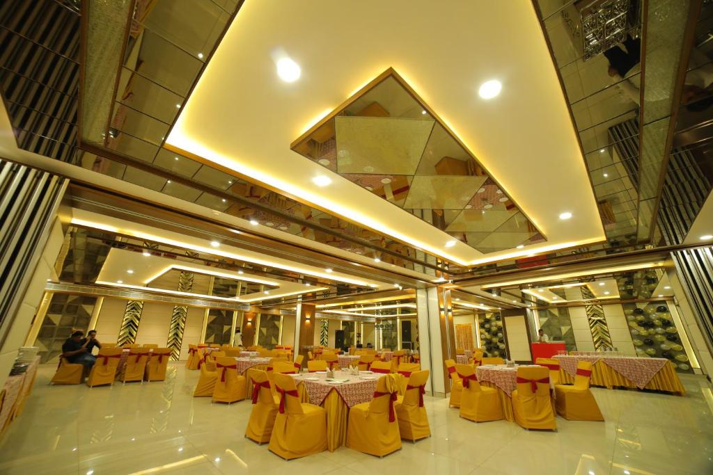 阿格拉Vijay Vilas Hotel & Convention Hall的宴会厅配有桌子和黄色椅子