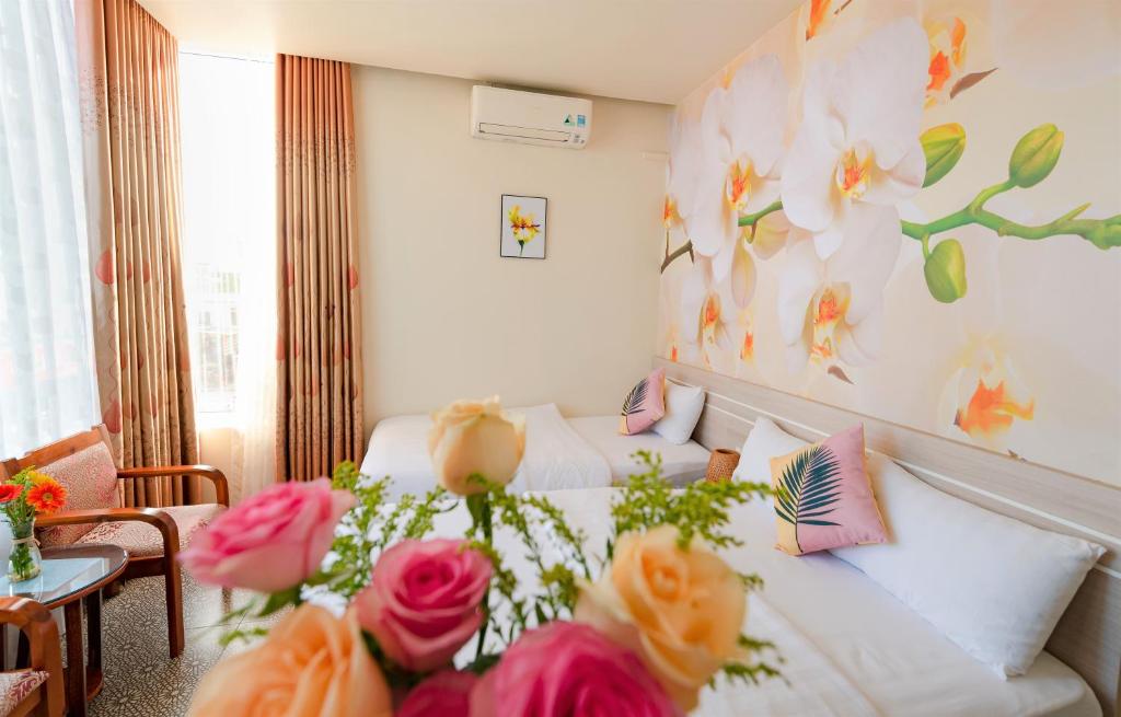顺化Flora Hotel Hue的一间卧室,床上放着鲜花