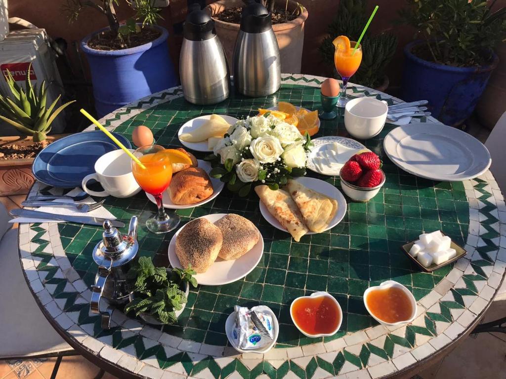 马拉喀什里亚德乔恩波尔摩洛哥传统庭院住宅的餐桌上放有食物盘子的桌子