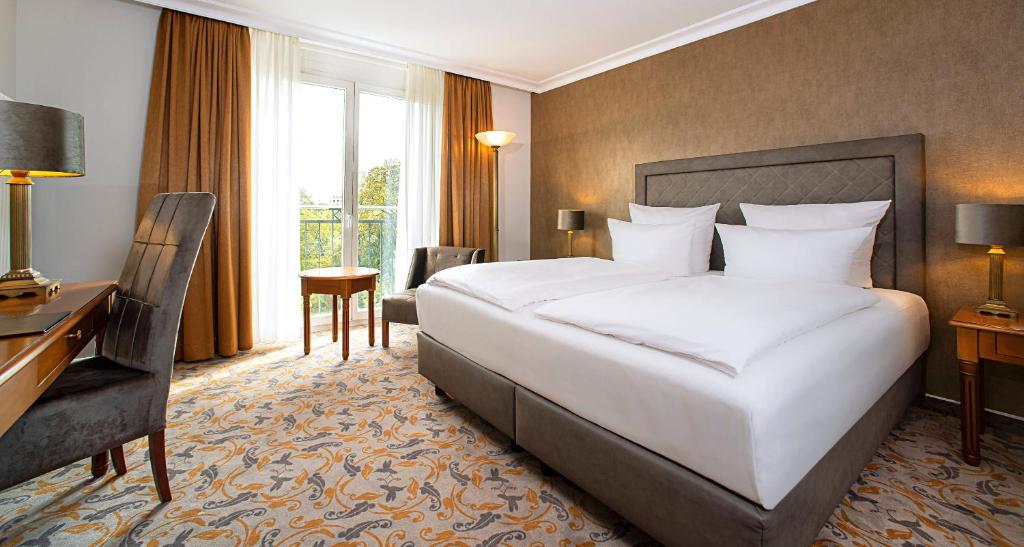 柏林维克多-柏林酒店的酒店客房设有一张大床和一张书桌。