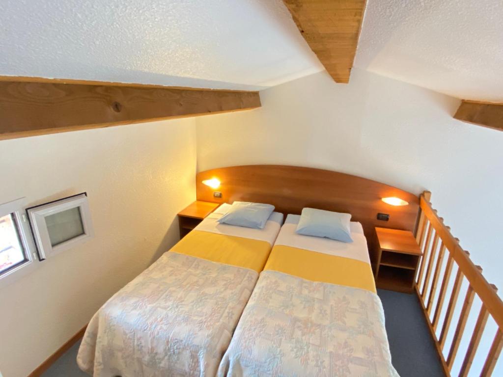 法扬斯Domaine De La Bégude的一间带两张床的小卧室和楼梯