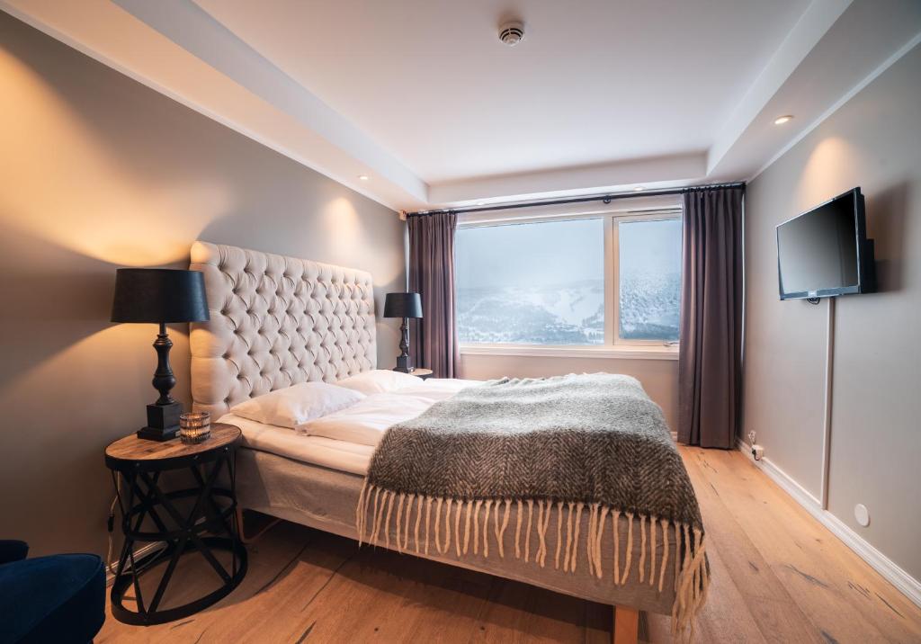 耶卢耶卢乌斯特达勒恩酒店的一间卧室设有一张大床和一个窗户。