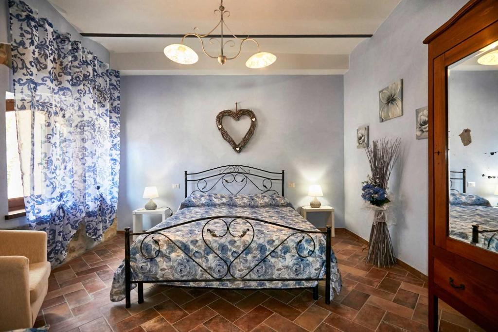 萨杜勒尼亚Agriturismo MonteCrespini的一间卧室配有蓝色和白色窗帘的床