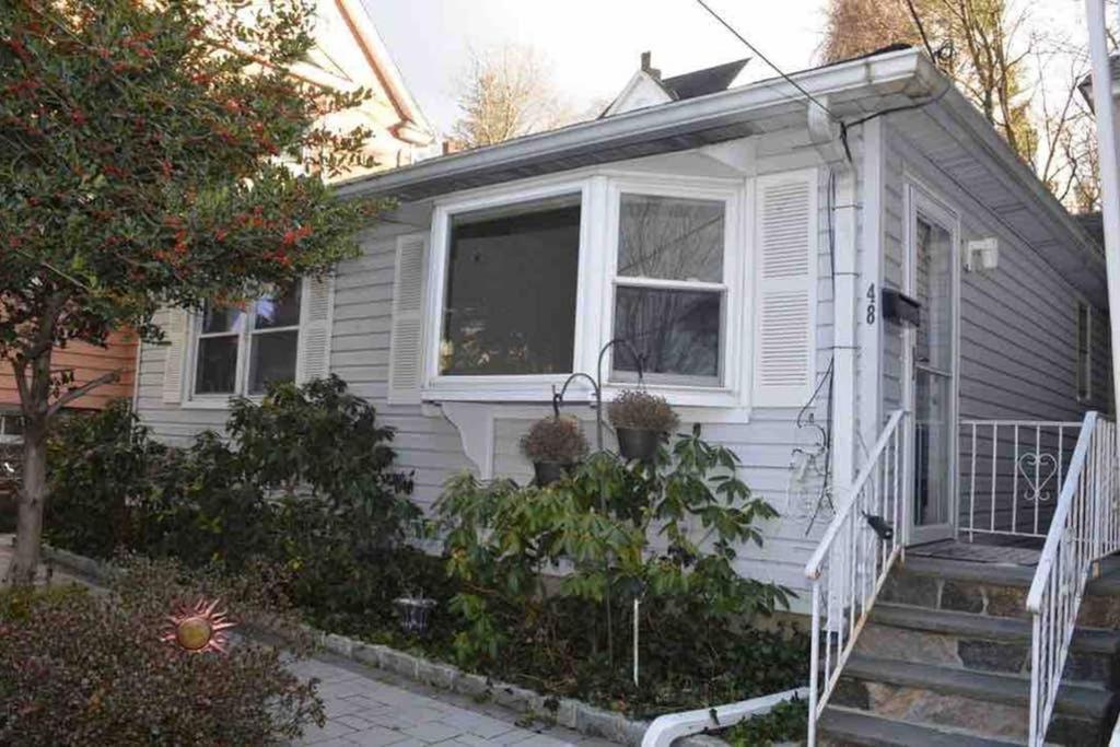扬克斯La Casita Bonita Near NYC的白色的小房子,设有楼梯和窗户