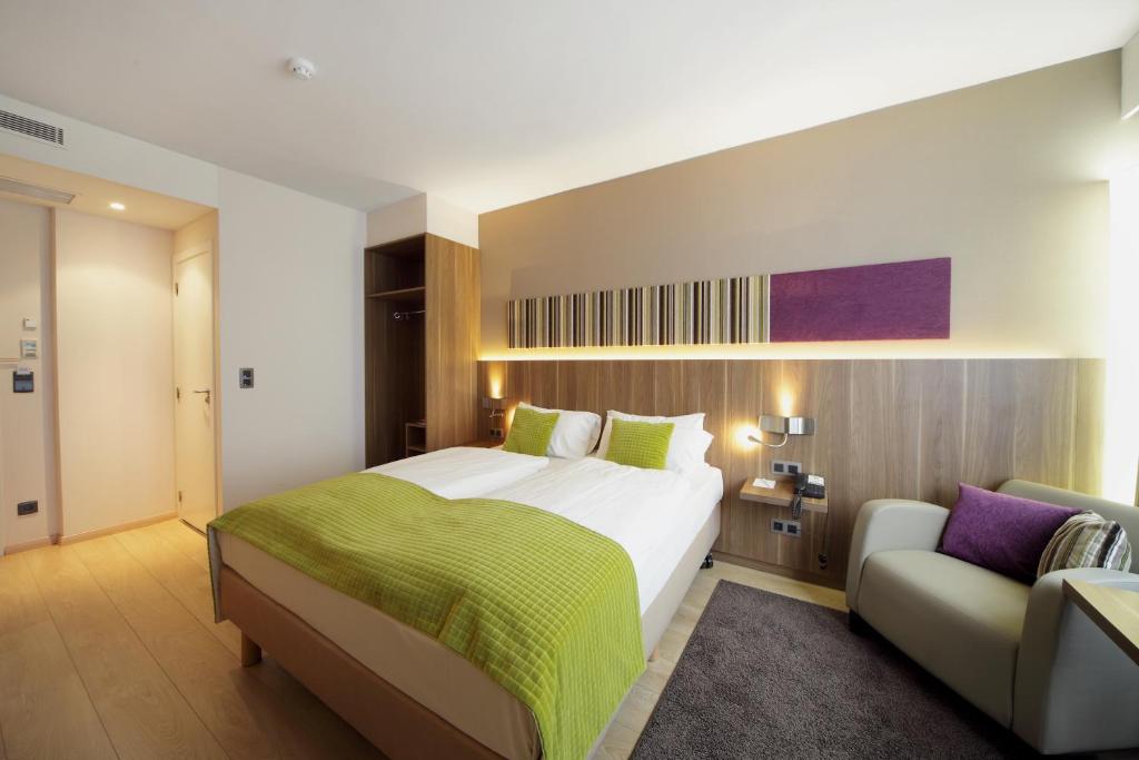 布鲁塞尔Holiday Inn Brussels Schuman, an IHG Hotel的一间卧室配有一张大床和一张沙发