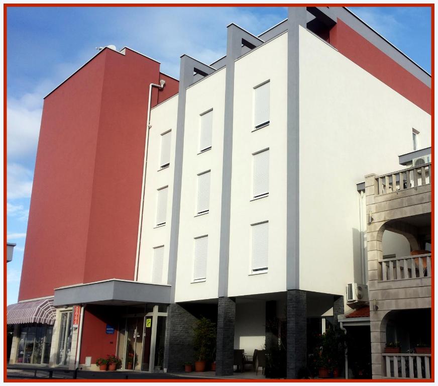 默主歌耶迪娜酒店的一座红色和白色的大建筑,有拱门
