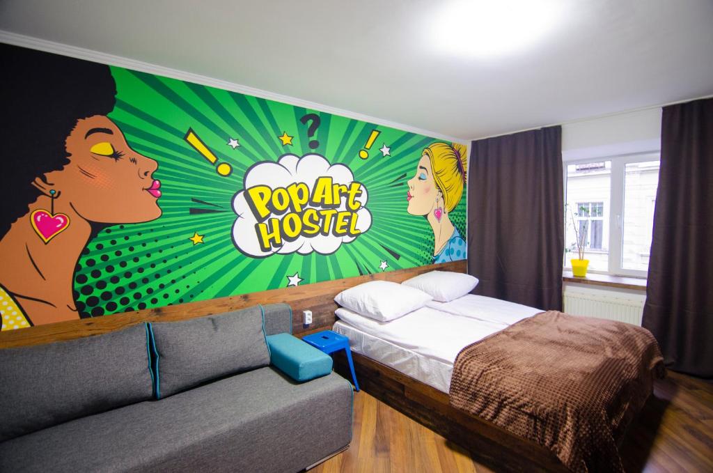 利沃夫Pop Art Hostel Rynok Sq的一间卧室配有一张床,墙上挂着绘画作品