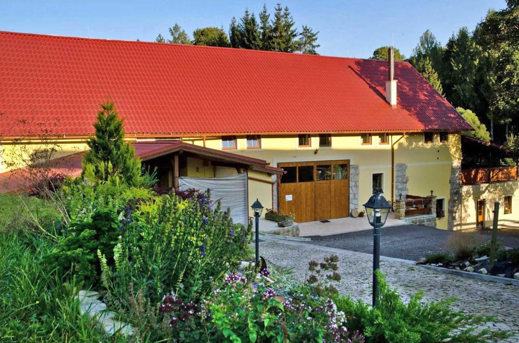 阿德尔什帕赫Penzion Tuček Adršpach的一座红色屋顶的房子和一个花园
