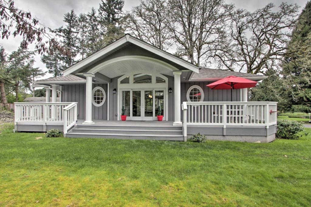 塔科马Contemporary Tacoma Cottage with Deck and Pond!的一座带门廊和红色雨伞的小房子