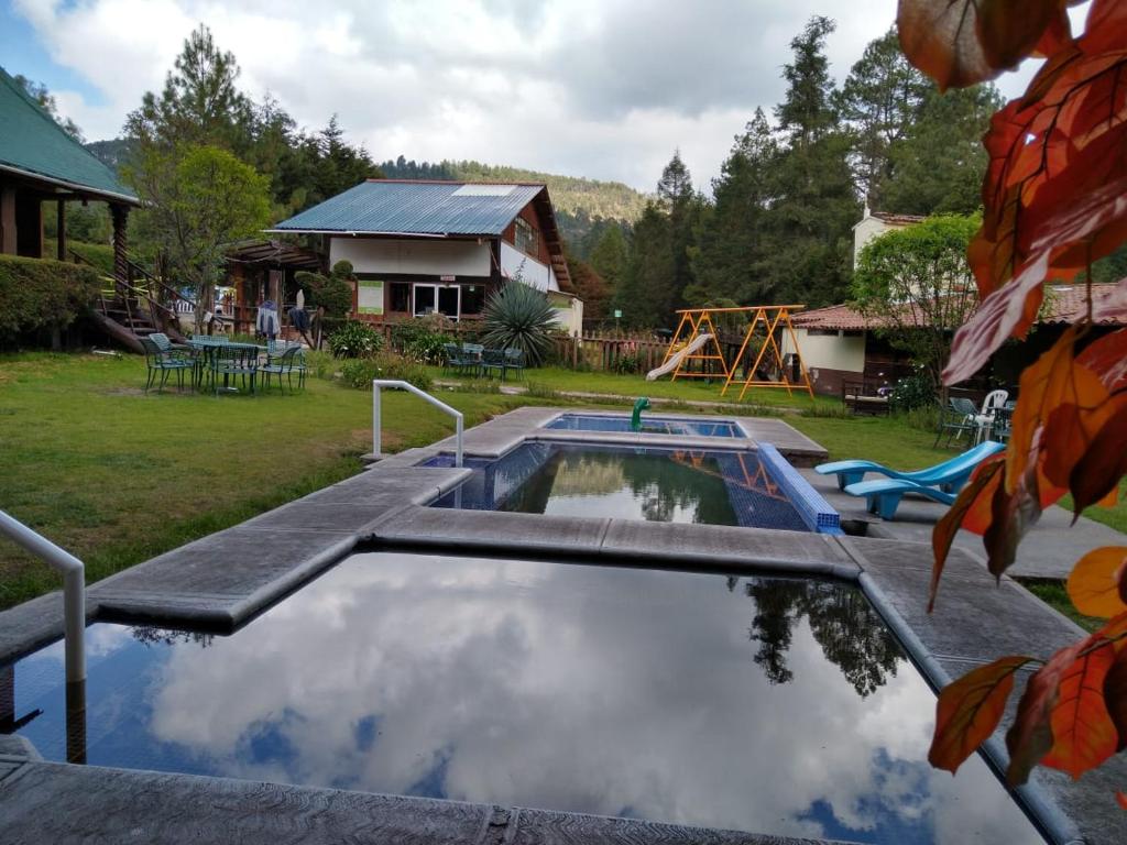 罗斯阿祖弗雷斯特亚玛尼赖斯俱乐部酒店的一座带房子的庭院内的游泳池