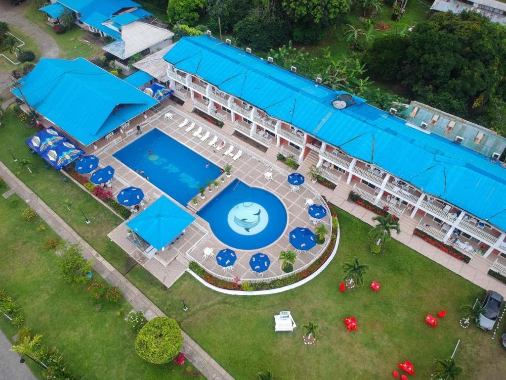 图马科Hotel & Resort Villa del Sol的享有带游泳池和蓝伞的度假村的空中景致