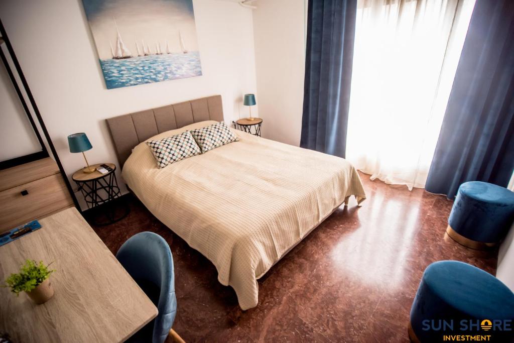 哈尔基斯Explore Greece from Lovely City Centre Apartment的卧室配有一张床和一张桌子及椅子