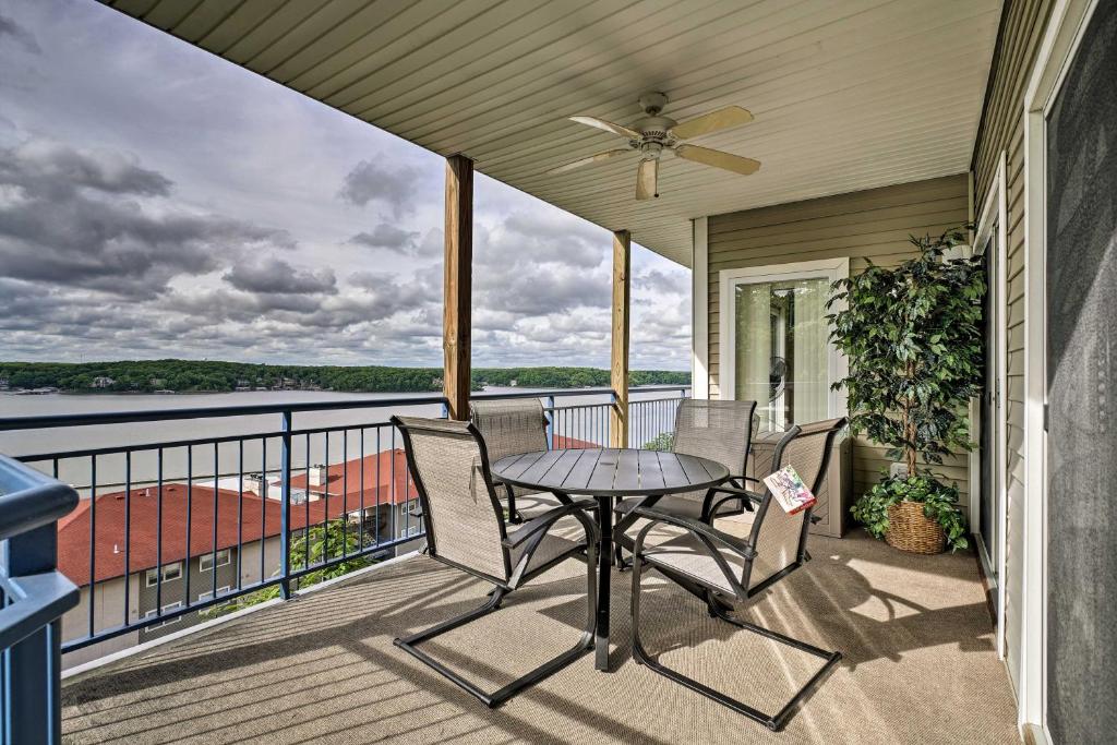 奥沙克湖Waterfront Lake Ozark Condo with Deck and Pools的阳台的天井配有桌椅