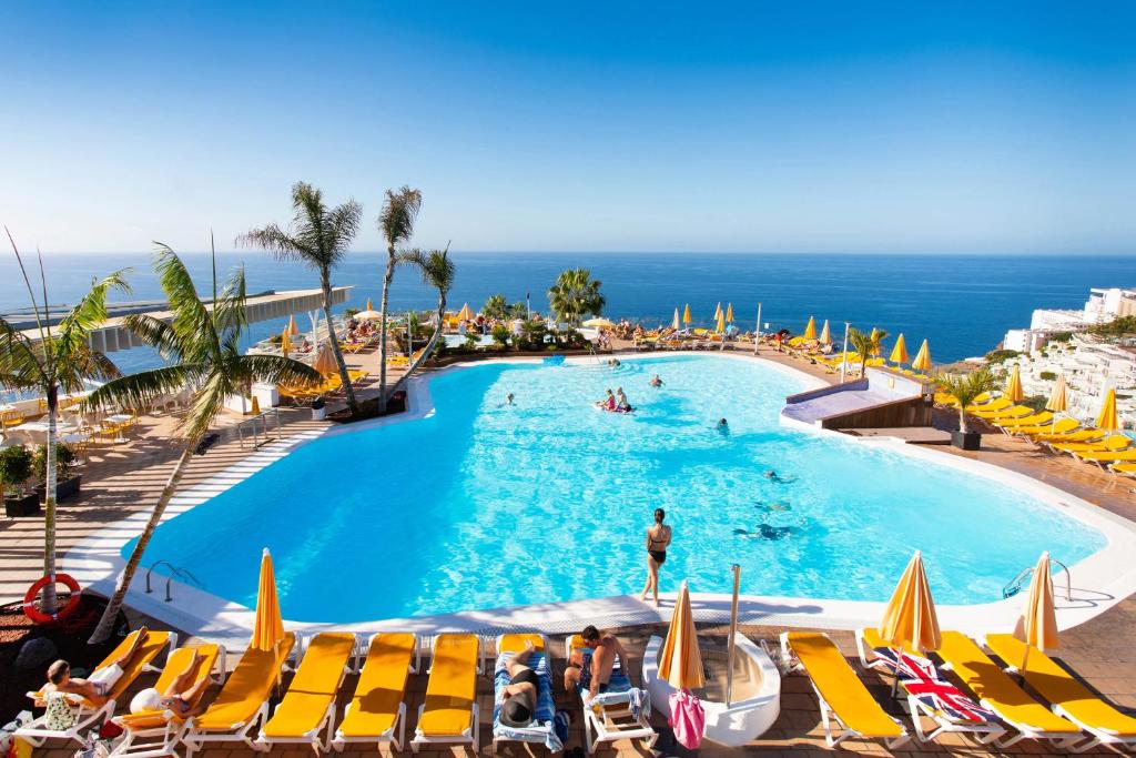 波多黎各里尔索尔酒店的一个带椅子的游泳池,背景是大海
