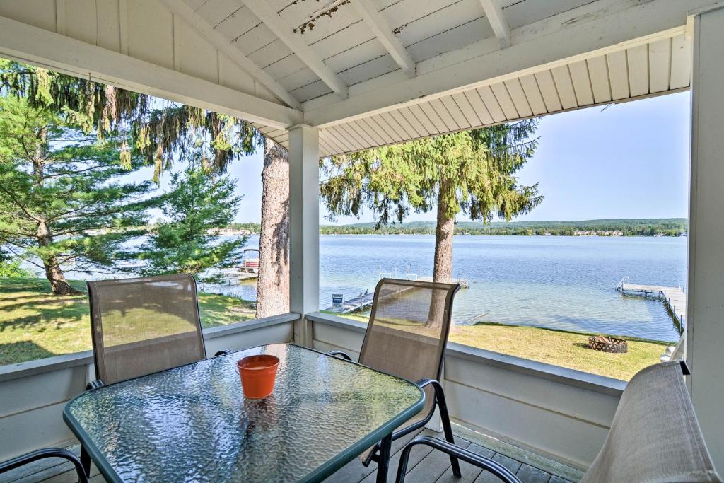 佩托斯基Petoskey Waterfront Cottage with Deck and Grill!的水景门廊上的桌椅