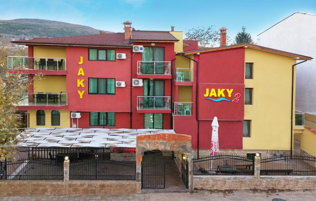 克兰内沃Hotel Jaky SPA Complex的红色和黄色的建筑,上面有 ⁇ 形标志