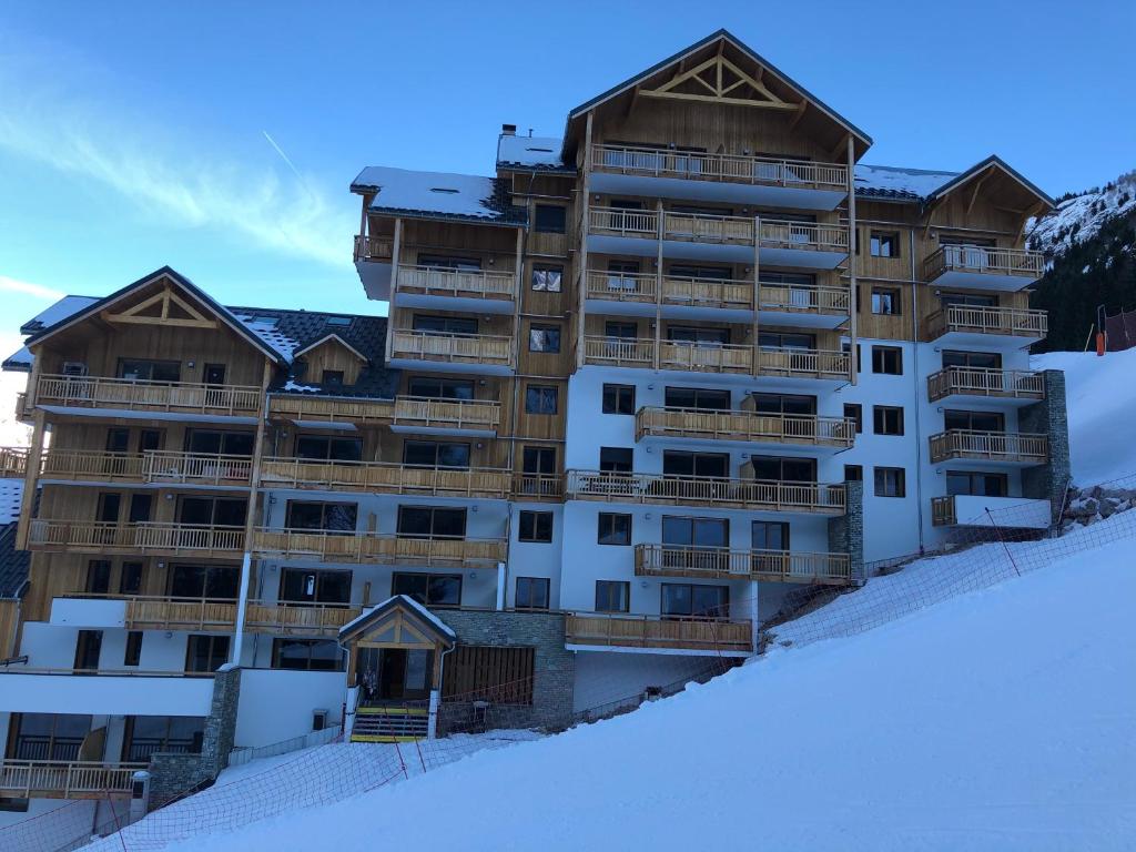 Oz*NEW* Bellevue D’Oz Ski In Ski Out Luxury Apartment (8-10 Guests)的一座位于雪覆盖斜坡顶部的大型公寓楼