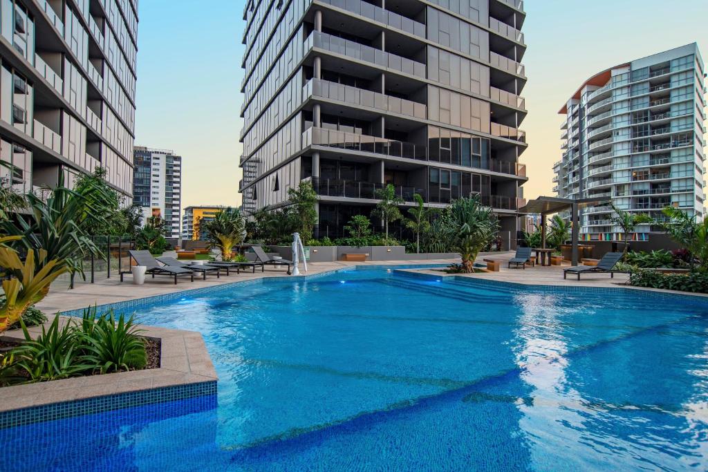 布里斯班Brisbane One Apartments by CLLIX的一个大型蓝色游泳池,其建筑背景为: