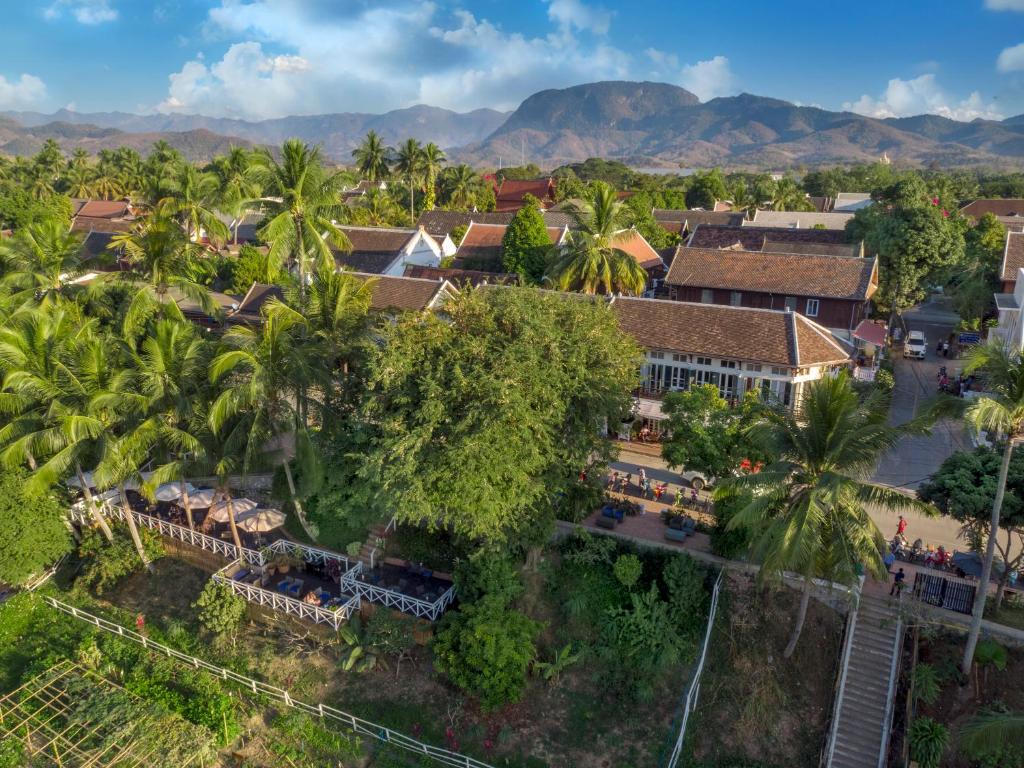 琅勃拉邦贝莱福精品酒店的享有棕榈树村庄和建筑的空中景致