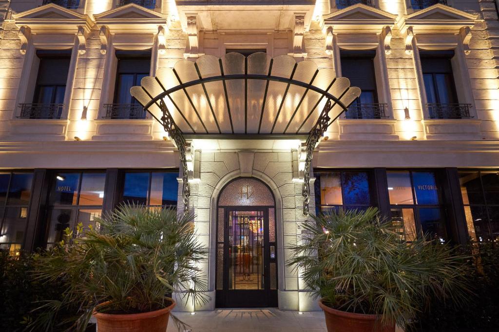 瓦朗斯Hotel Victoria的一座大建筑,前面有门和植物