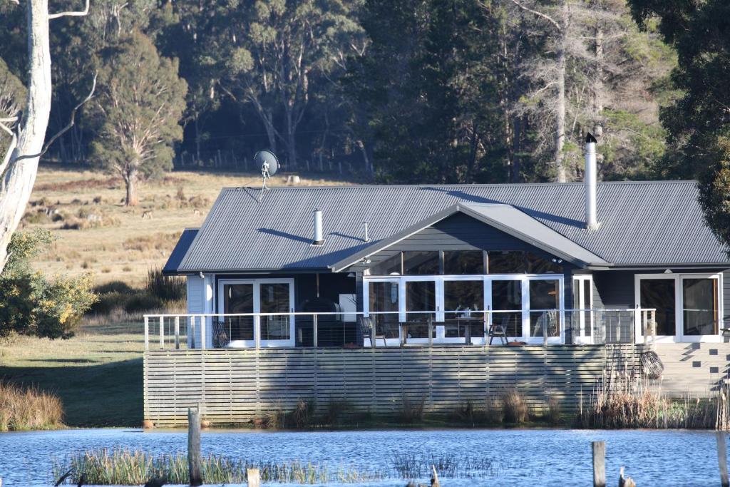 Lake Leake塔斯马尼亚澳洲喜鹊湖山林小屋的水面上的房子,顶上的房子