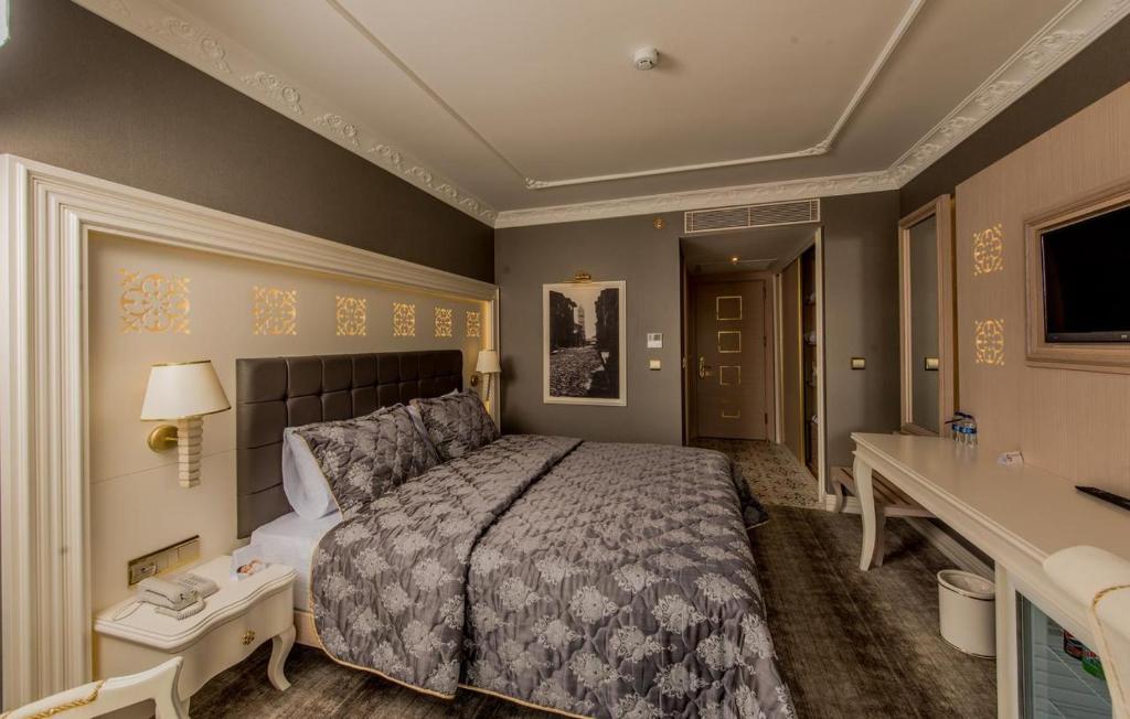 巴勒克埃西尔Altın Otel & Spa Balıkesir的一间卧室配有一张床、一张桌子和一个水槽