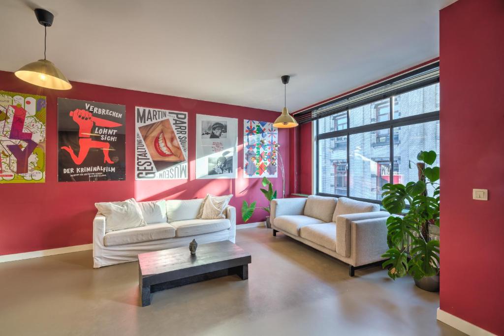 安特卫普Apartment with Rooftop Terrace in the Heart of Antwerp的客厅设有两张沙发和一堵红色的墙