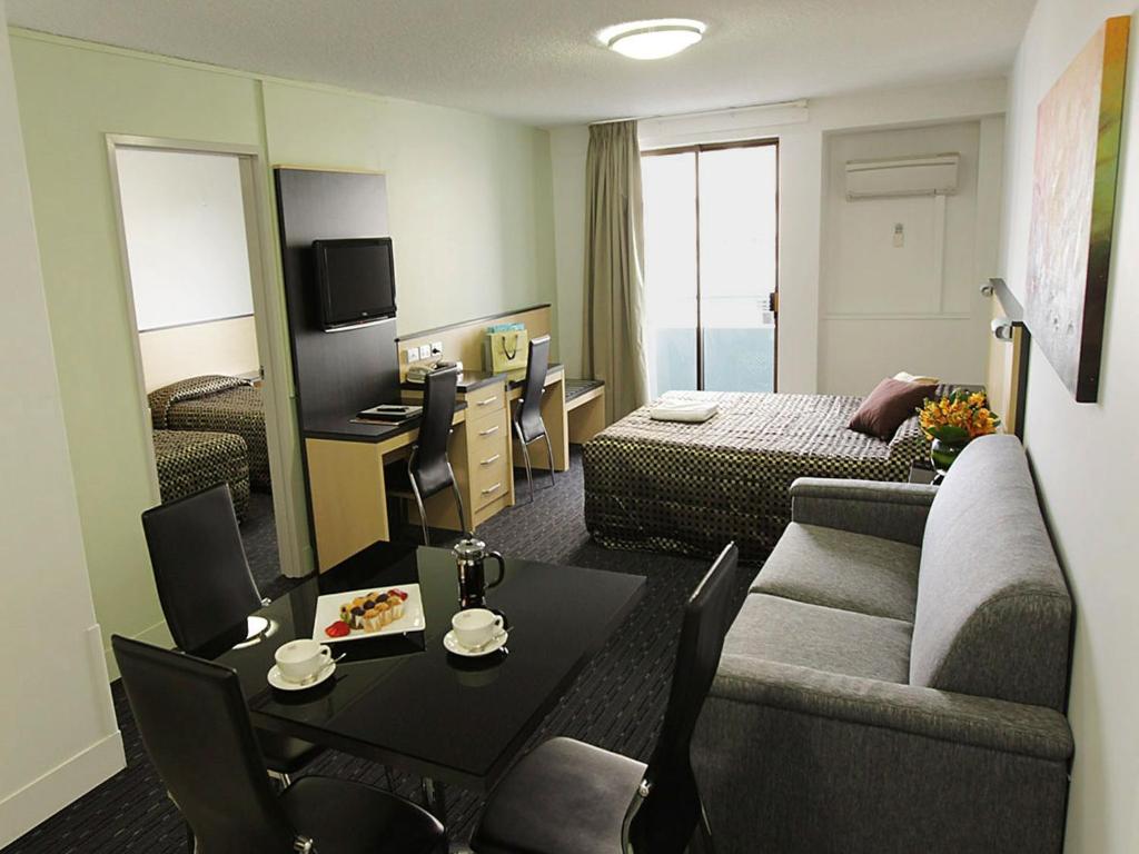珀斯珀斯古蒂尔斯康福特茵套房酒店的一间客厅,客厅配有沙发和一张桌子,位于酒店的房间
