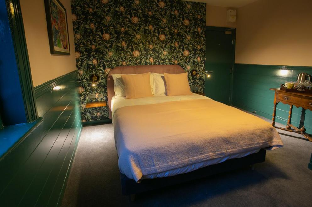伦敦The Ship Rooms的一间卧室设有一张大床和绿色的墙壁