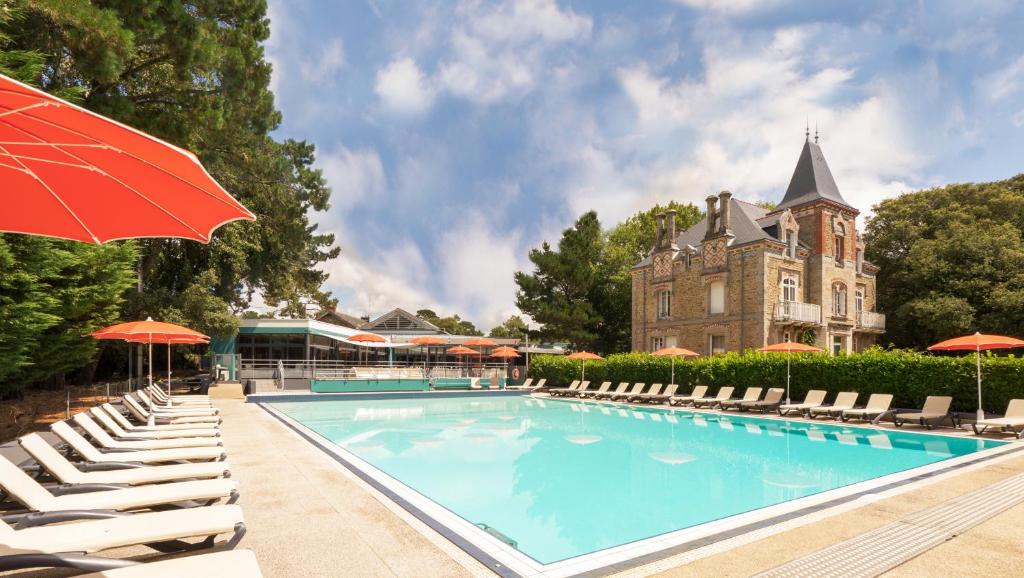 波尔尼谢雷斯当斯酒店的一座带椅子和遮阳伞的游泳池以及一座建筑