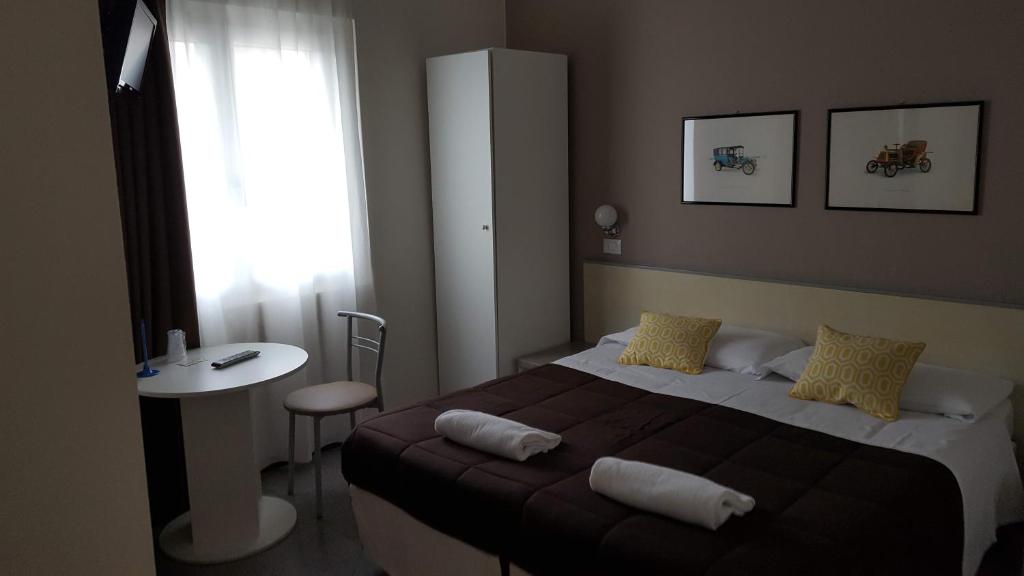 伊塞奥阿利安娜酒店的一间卧室配有一张床、一张桌子和一个窗户。