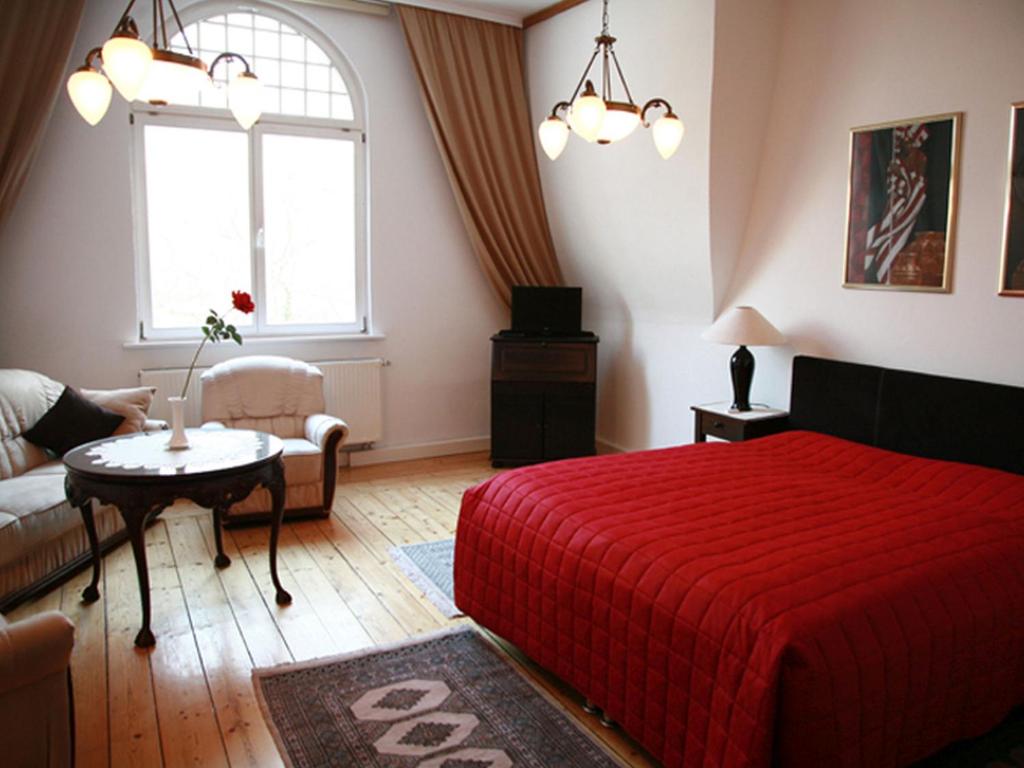 魏玛Villa Ingrid的一间卧室配有红色的床和一张沙发