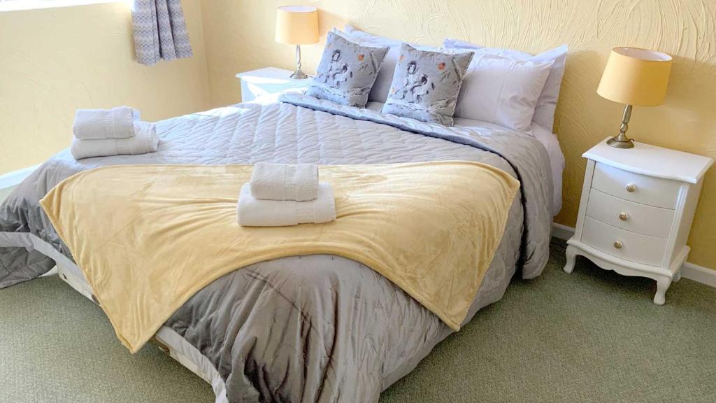 锡德茅斯Cider Cottage - 3 Bedroom - Onsite Parking的一间卧室配有一张大床和毛巾