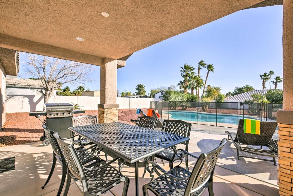 拉斯维加斯Updated Las Vegas House Patio and Solar Heated Pool的一个带桌椅的庭院和一个游泳池