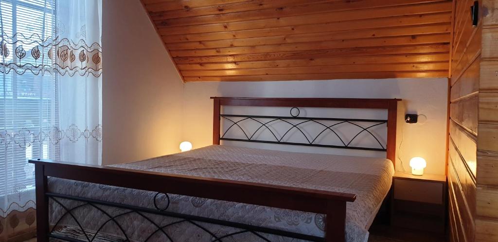赫拉布斯Víkendový domček Tis的卧室内的一张床铺,设有木制天花板