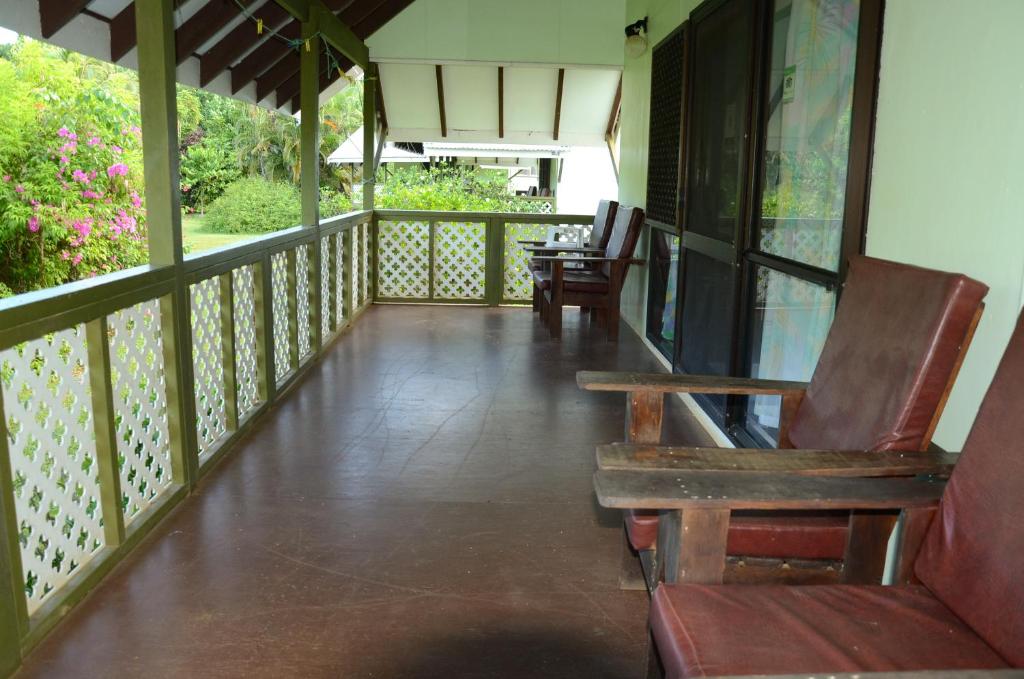 阿鲁坦加吉娜的花园酒店的门廊配有两把椅子和长凳