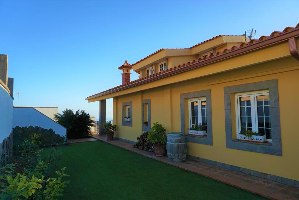 特尔德Pedro's house with fantastic views的绿色草坪的黄色房子