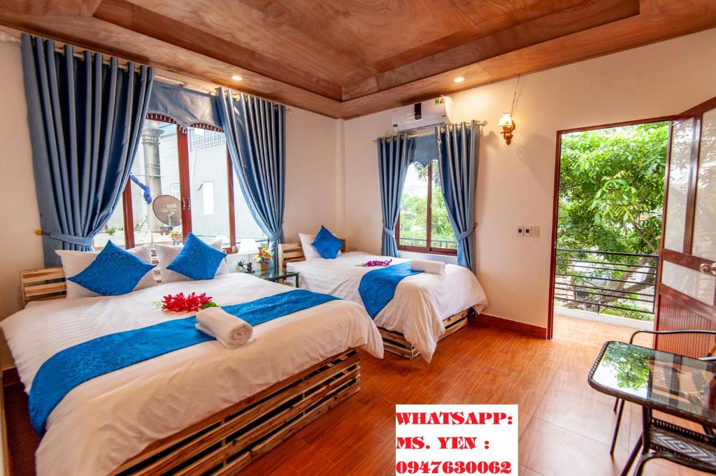 宁平Khai Yen Tam Coc Hostel的一间卧室配有两张蓝色窗帘的床