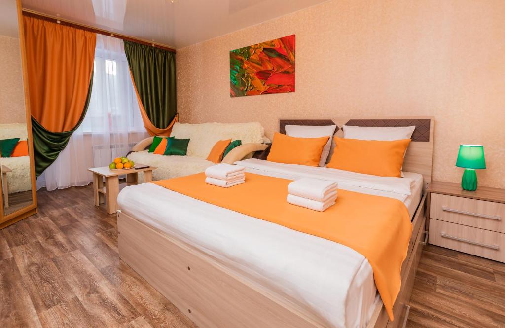 苏尔古特Five Stars Planet Of Health的一间卧室配有一张带橙色和白色枕头的大床